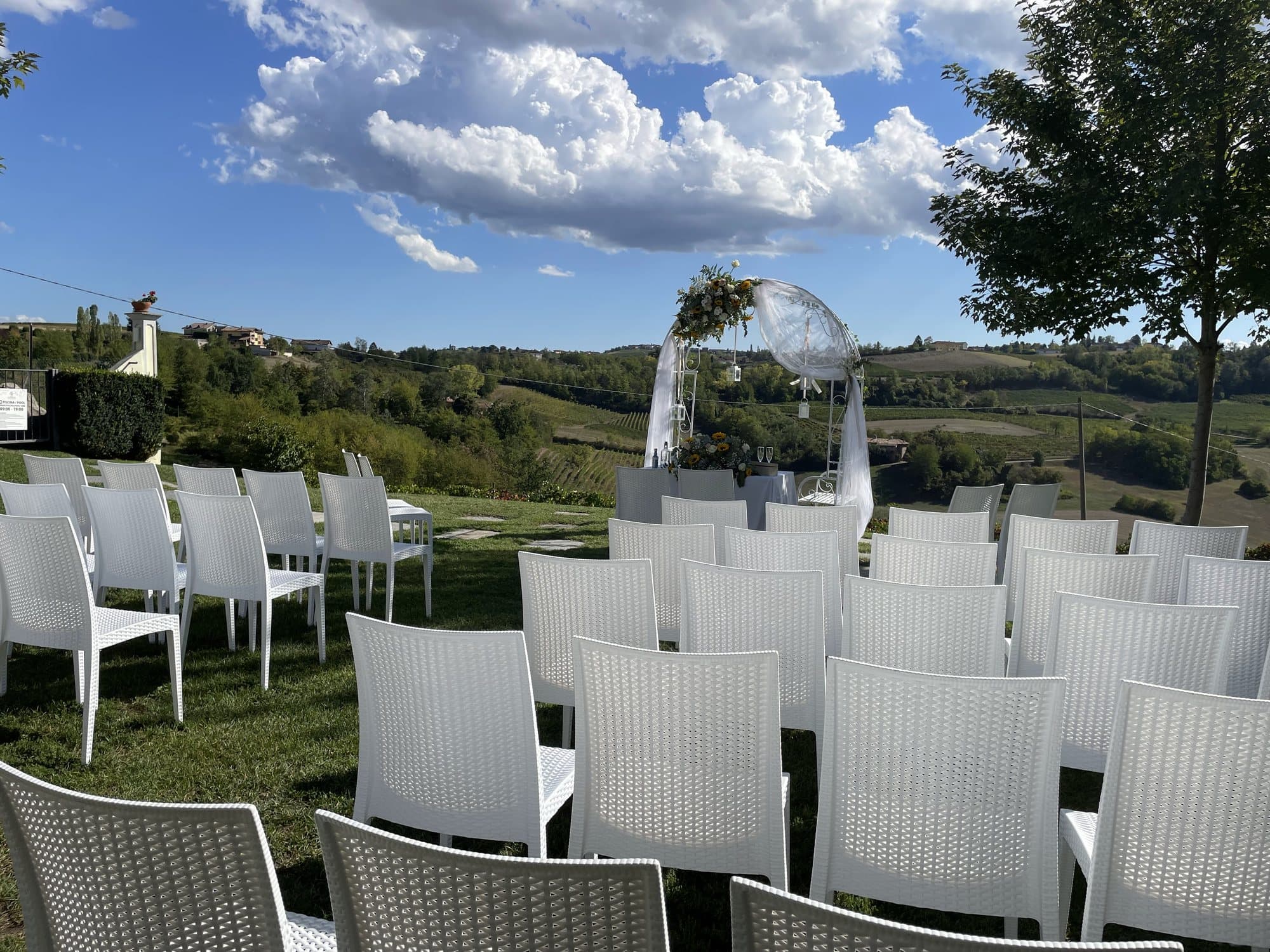 Cerimonia con arco floreale e vista sulle colline